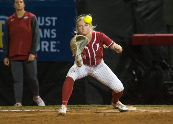 Alabama Crimson Tide utility Lauren Esman (9) makes a catch at first for an out during a quarterfinal game against the Arkansas Razorbacks in the SEC Softball Tournament.